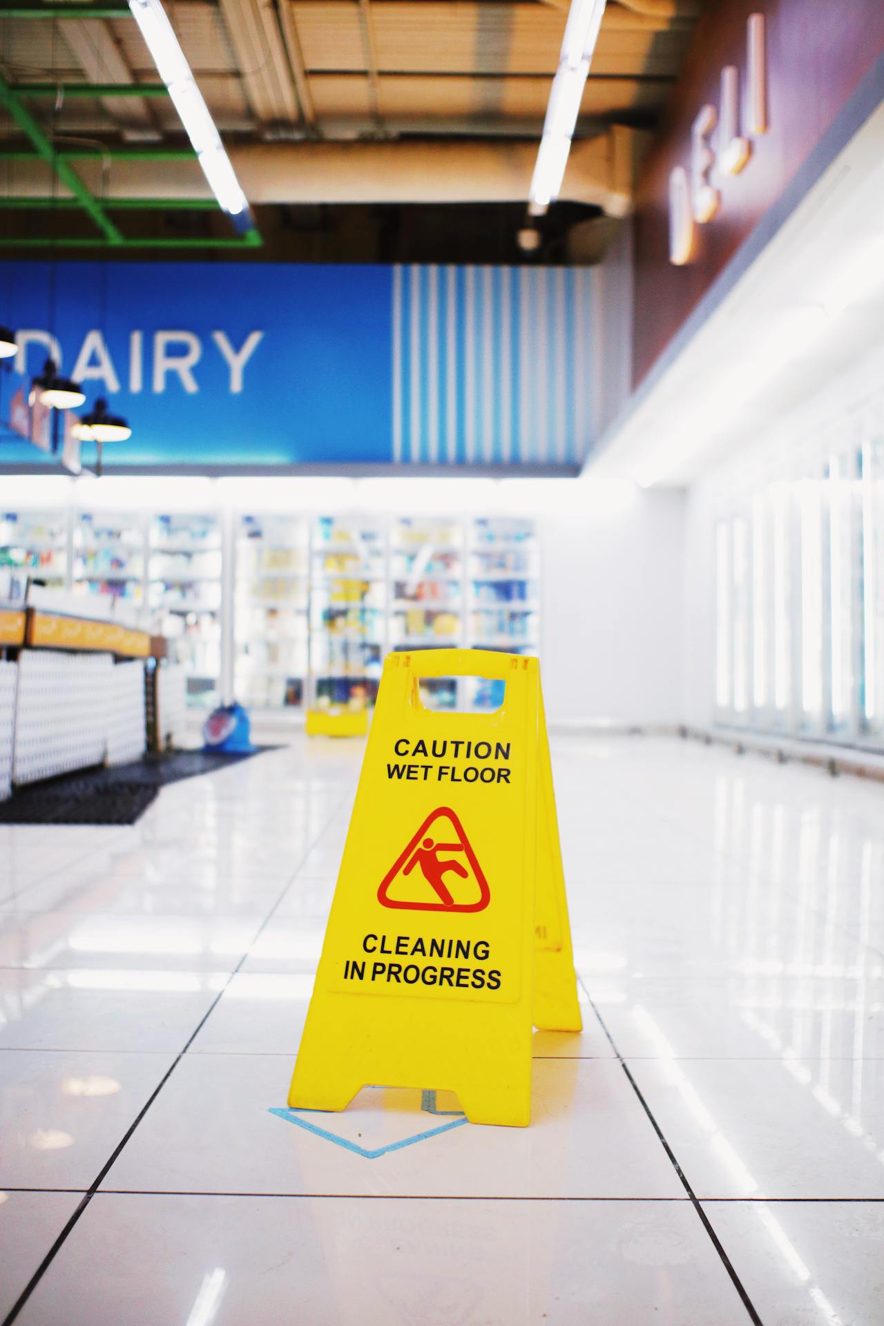 Retail store aisle with wet floor warning sign indicating a temporary slip hazard